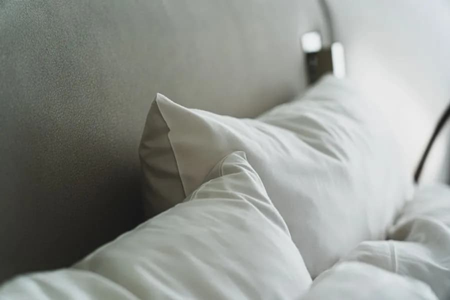 Almohadas blancas sobre la cama, catálogo de almohadas al por mayor